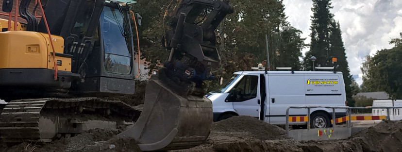 Tehin moottorin huoltoauto kaivinkoneen vieressä