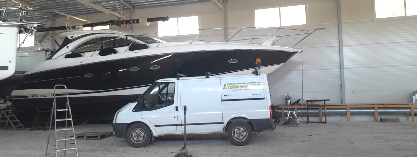 Tehin moottorin huoltoauto veneen vieressä